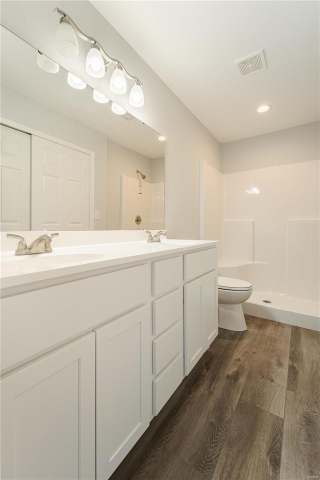 bathroom with vanity, toilet, wood-type flooring, and walk in shower