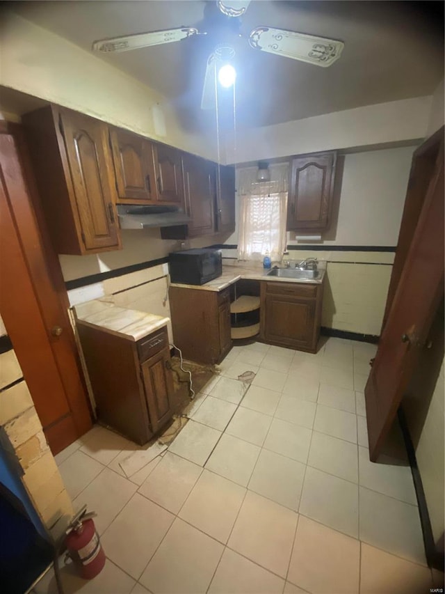 kitchen with light tile patterned floors, ceiling fan, and sink