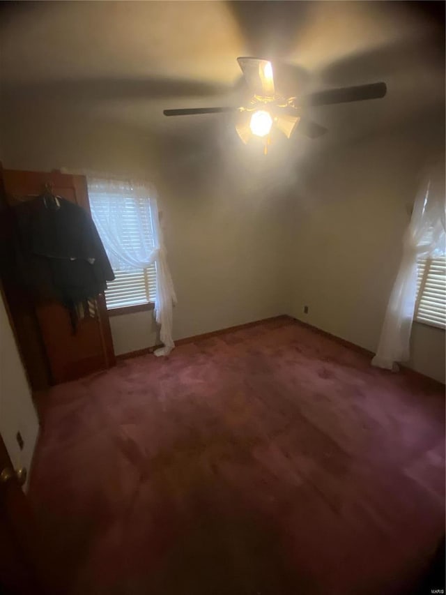 carpeted empty room with plenty of natural light and ceiling fan