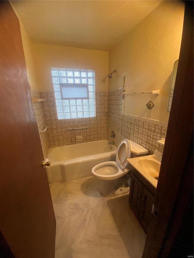 full bathroom with shower / tub combination, vanity, toilet, and tile walls