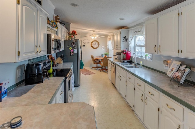 kitchen with sink, ceiling fan, a textured ceiling, appliances with stainless steel finishes, and white cabinetry