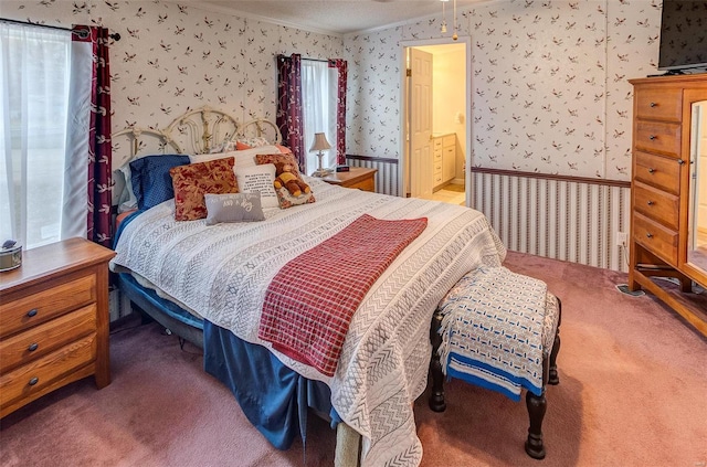 bedroom with connected bathroom, carpet floors, and ornamental molding