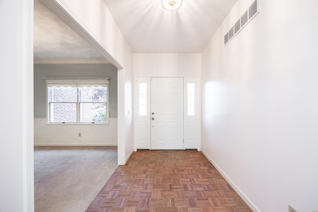 entrance foyer with dark parquet floors and crown molding