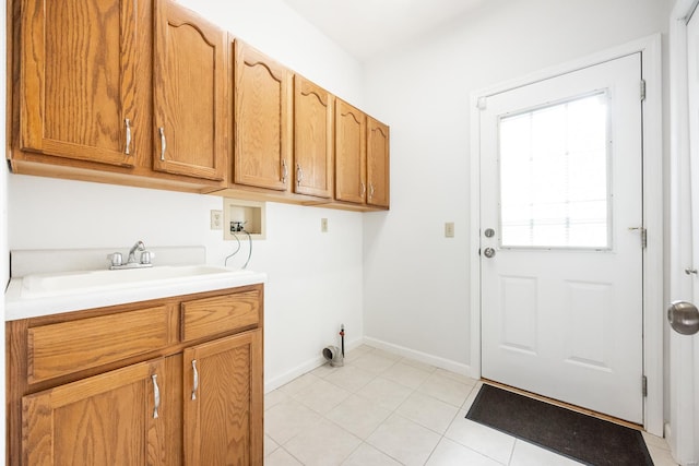 clothes washing area featuring washer hookup, light tile patterned flooring, cabinets, and sink