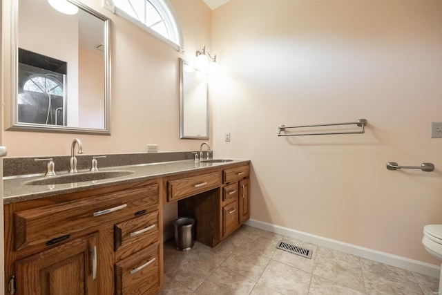 bathroom featuring tile patterned flooring, vanity, and toilet