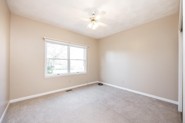 spare room featuring light carpet and ceiling fan