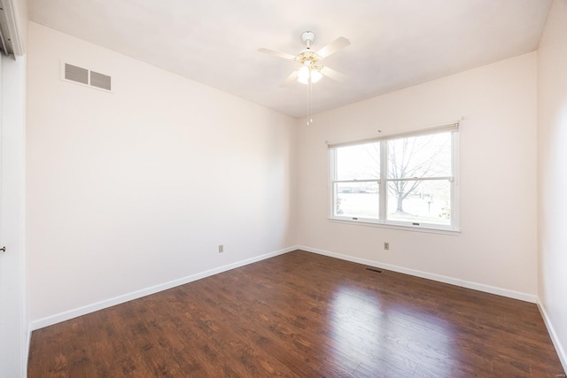 spare room with ceiling fan and dark hardwood / wood-style flooring