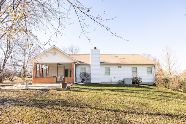 rear view of house featuring a lawn, ceiling fan, and cooling unit