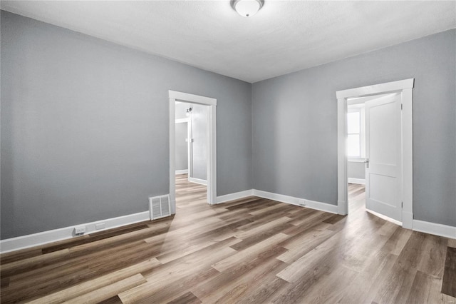 empty room featuring a textured ceiling and hardwood / wood-style flooring