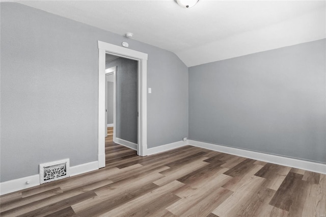 additional living space featuring hardwood / wood-style flooring and vaulted ceiling