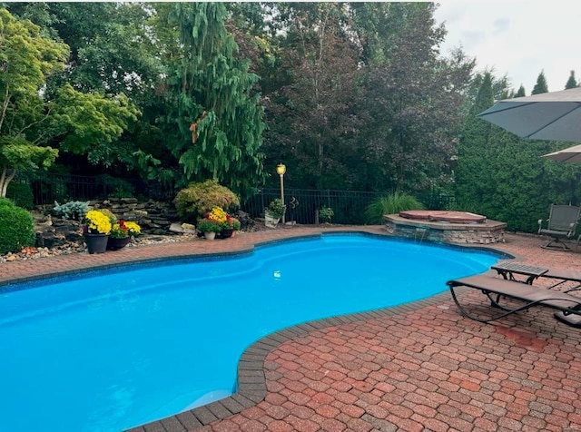 view of swimming pool with a patio area and an in ground hot tub