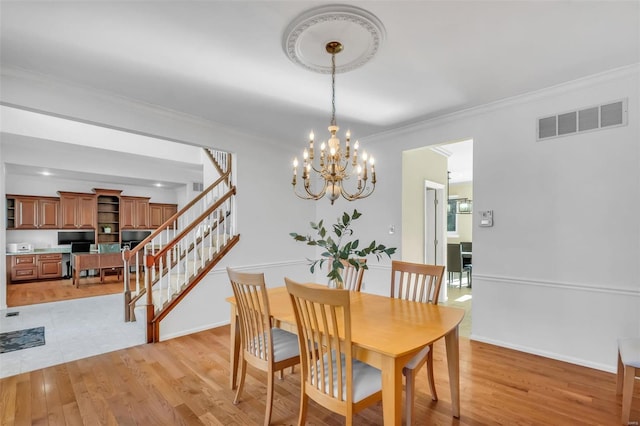 dining area with crown molding and light wood-type flooring