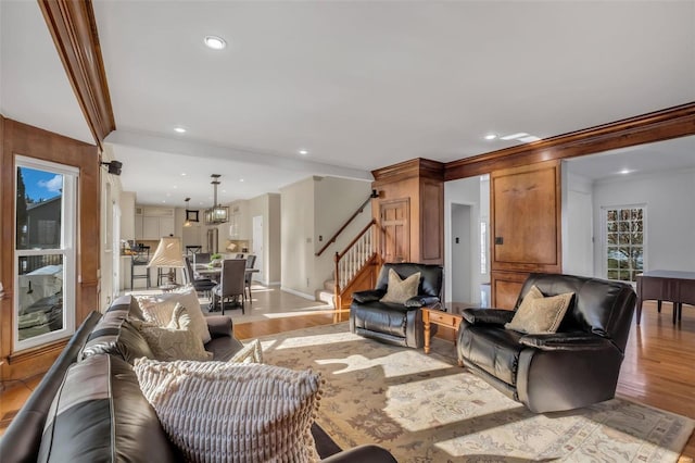 living room featuring light wood-type flooring and ornamental molding