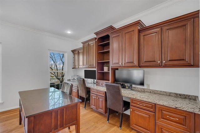 office area with built in desk, crown molding, and light hardwood / wood-style flooring