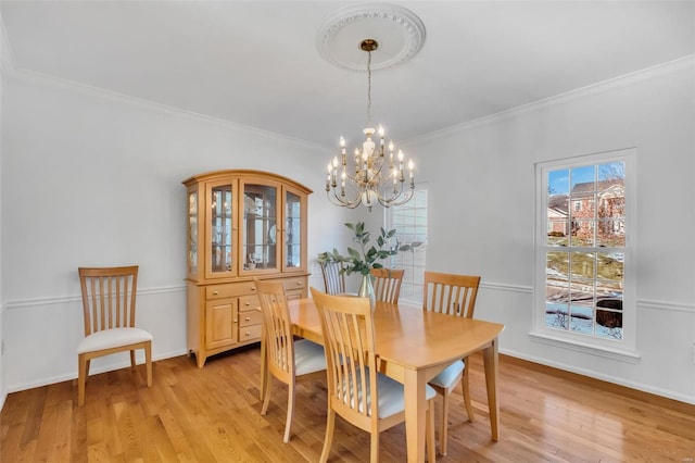 dining room with light hardwood / wood-style floors, ornamental molding, and a healthy amount of sunlight