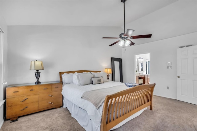 bedroom with vaulted ceiling, ceiling fan, light carpet, and ensuite bath