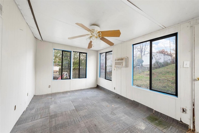 unfurnished room featuring a wall mounted AC and ceiling fan