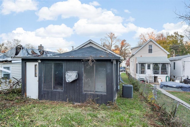 view of outdoor structure featuring central air condition unit and a yard