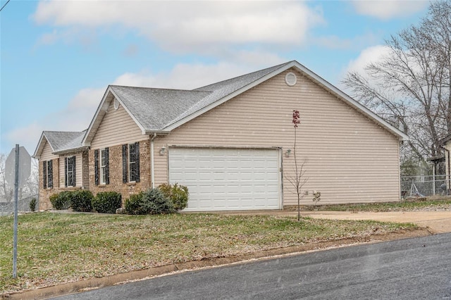 view of side of home with a lawn and a garage