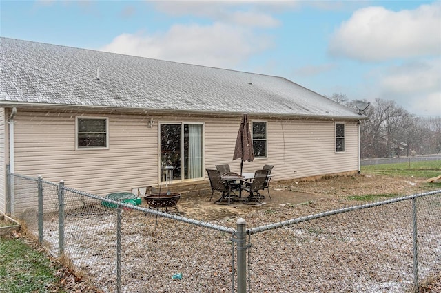 rear view of property featuring an outdoor fire pit