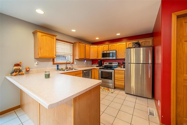 kitchen with kitchen peninsula, sink, light tile patterned floors, and appliances with stainless steel finishes