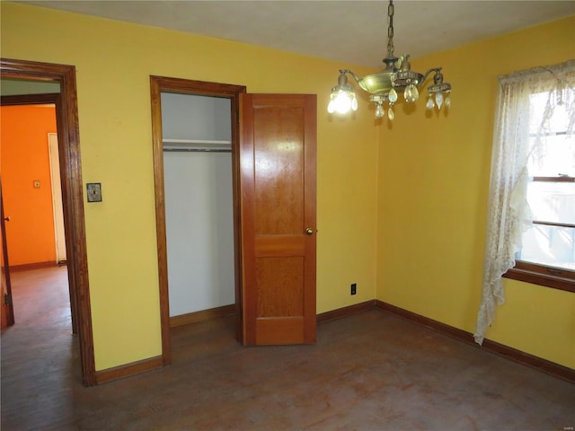 unfurnished bedroom featuring a closet and a chandelier