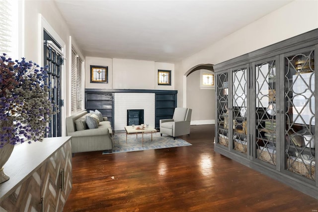 living room with a fireplace, french doors, and dark wood-type flooring