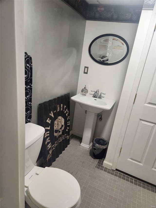 bathroom featuring tile patterned flooring, toilet, and sink