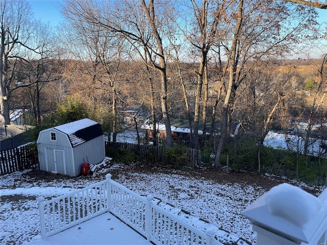 yard layered in snow featuring a storage shed