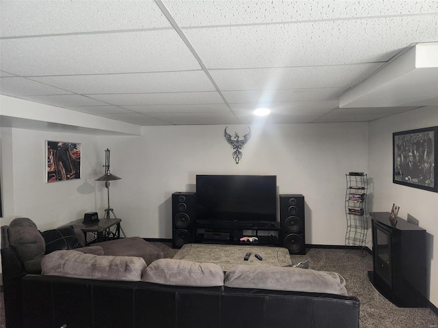 living room featuring a paneled ceiling, carpet, and a wood stove