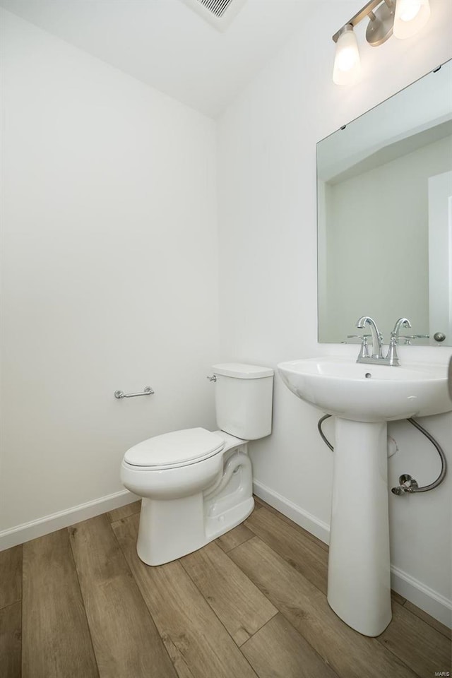 bathroom featuring hardwood / wood-style floors and toilet