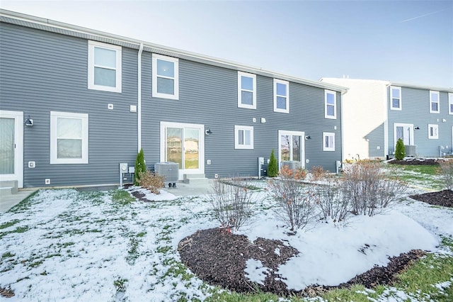 snow covered house with central AC unit