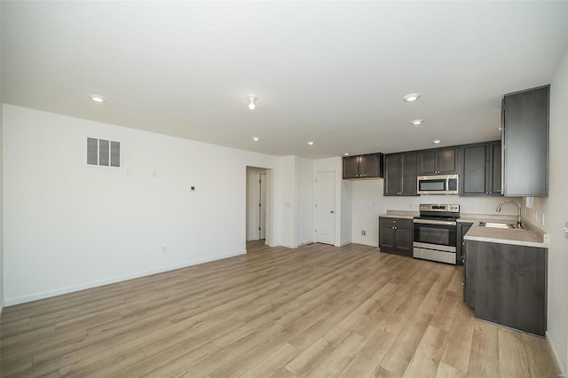 kitchen featuring light wood-type flooring, sink, and appliances with stainless steel finishes