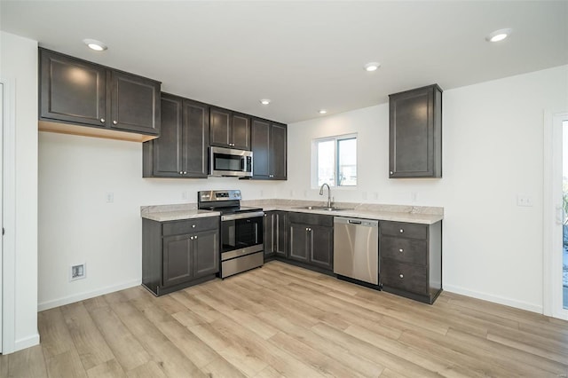 kitchen featuring sink, light wood-type flooring, and appliances with stainless steel finishes