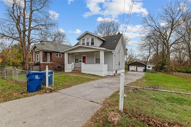 bungalow with a front yard, a garage, an outdoor structure, and covered porch