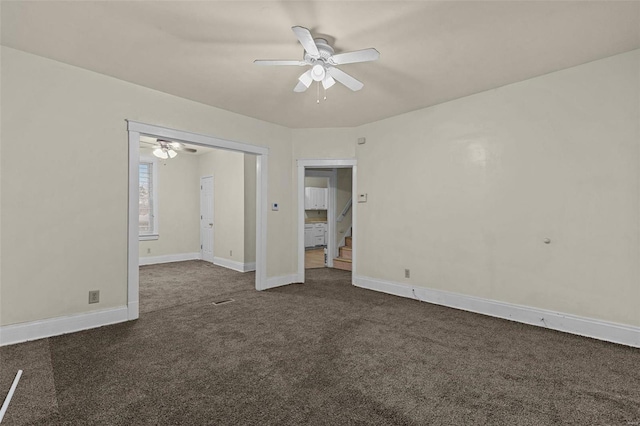 empty room featuring ceiling fan and dark carpet