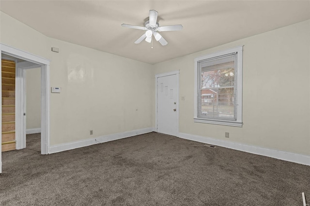 carpeted spare room featuring ceiling fan