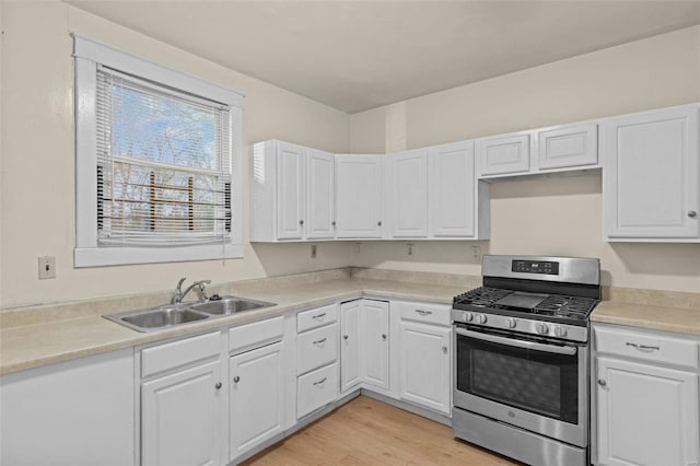 kitchen featuring sink, white cabinets, light hardwood / wood-style flooring, and stainless steel range with gas stovetop