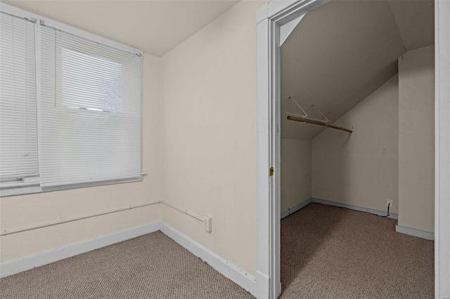 walk in closet featuring light carpet and vaulted ceiling