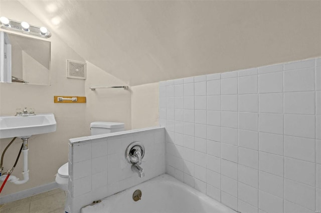 bathroom with lofted ceiling, sink, tile patterned flooring, a washtub, and toilet