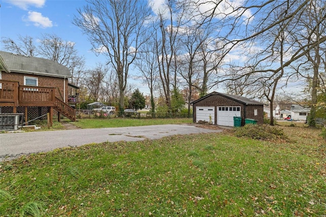 view of yard with an outbuilding, a garage, and a wooden deck