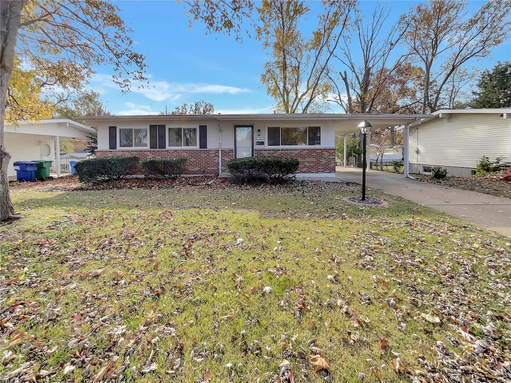 ranch-style home featuring a front yard and a carport