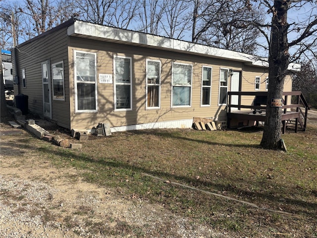 view of front of property with a front yard and a wooden deck