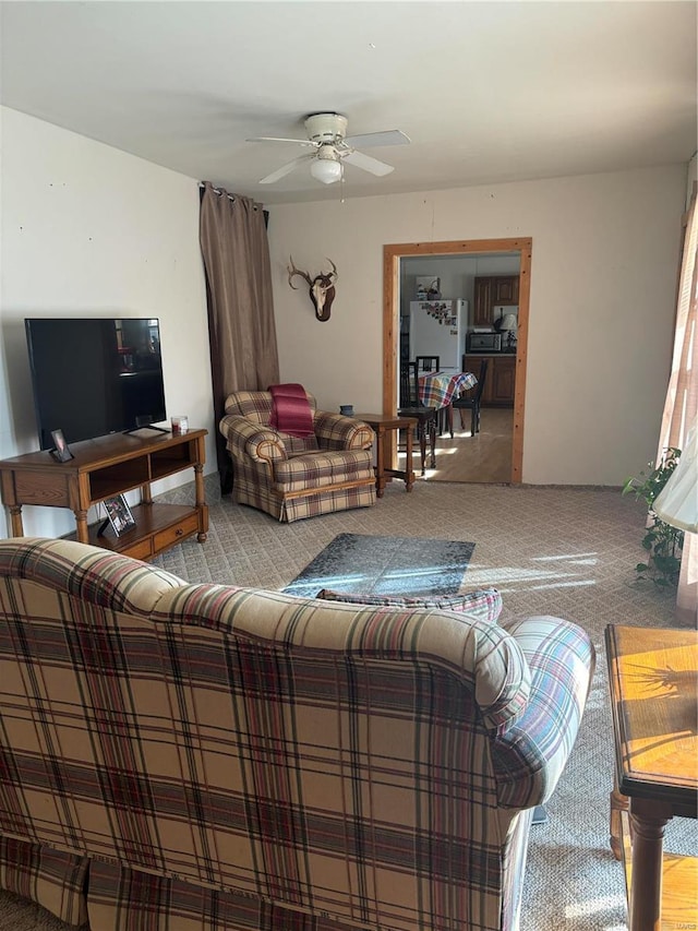 carpeted living room with ceiling fan