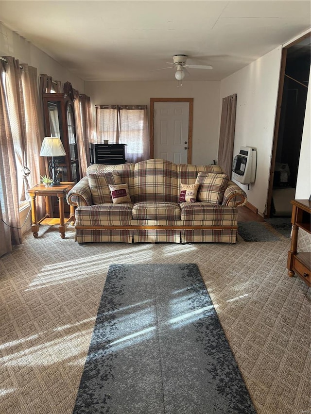 living room with ceiling fan, carpet floors, and heating unit