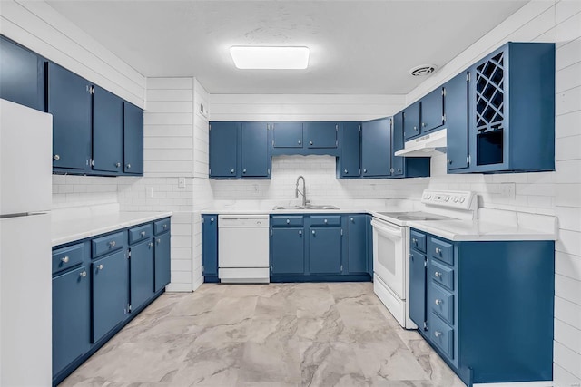 kitchen with white appliances, sink, blue cabinets, and tasteful backsplash