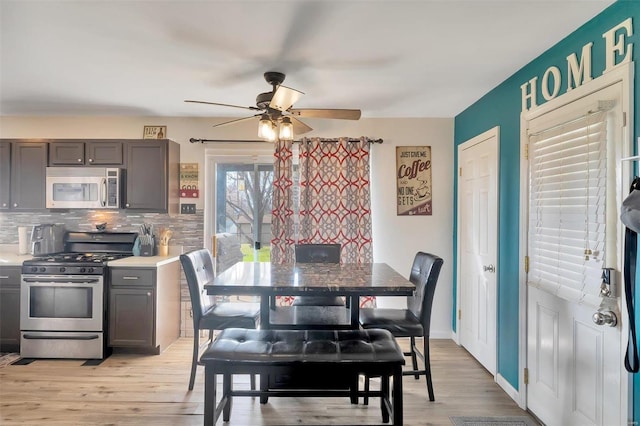 dining room featuring light wood-style flooring, baseboards, and ceiling fan