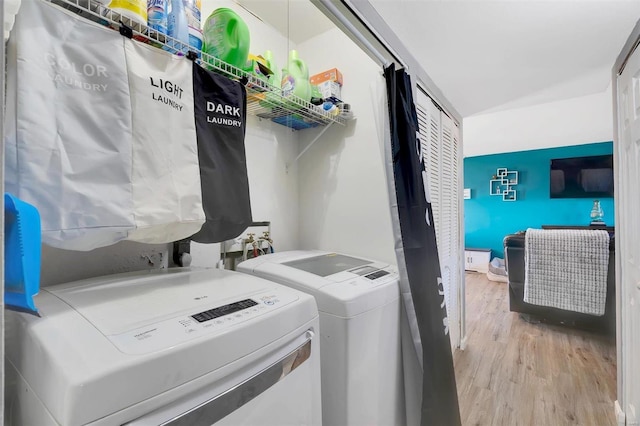 laundry room featuring separate washer and dryer, wood finished floors, and laundry area