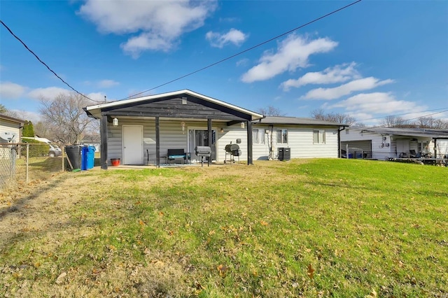 back of property featuring central AC unit, a lawn, and fence