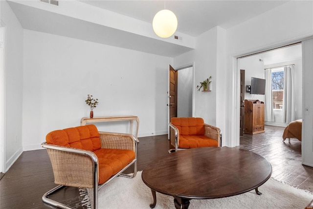 sitting room with dark wood-type flooring